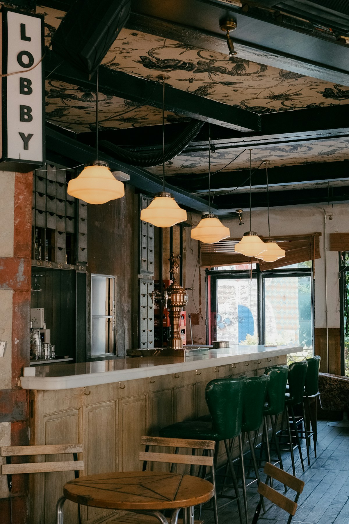 Bar-interieur met groene barkrukken en warme hanglampen